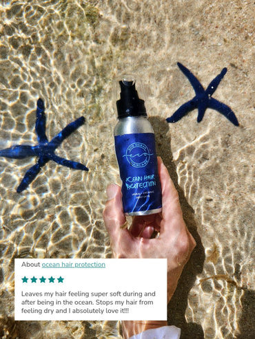 Hand holding a bottle of Evercircle Ocean hair protection serum under water with blue starfish in the background.