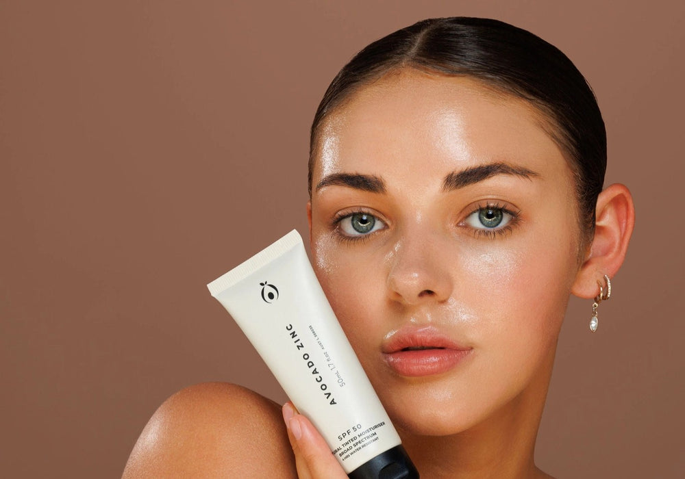 Women holding a tube of avocado zinc tinted SPF moisturiser face care