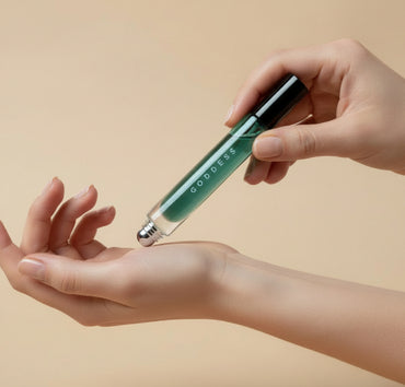 A tube of non-toxic perfume roller oil being rolled onto a womans wrist