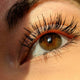 How to get thicker lashes with natural growth tips. Picture of woman's eye and thick healthy lashes. Unfurl