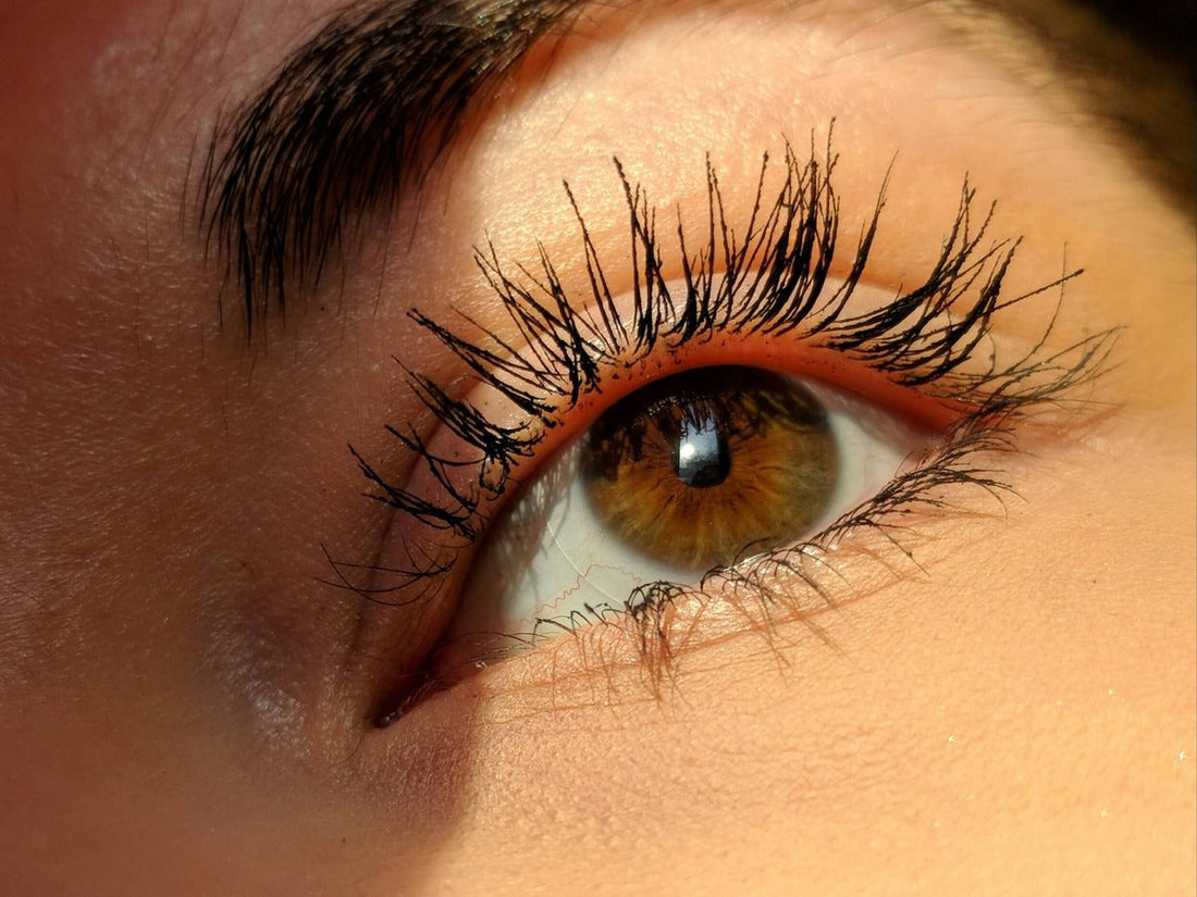 How to get thicker lashes with natural growth tips. Picture of woman's eye and thick healthy lashes. Unfurl