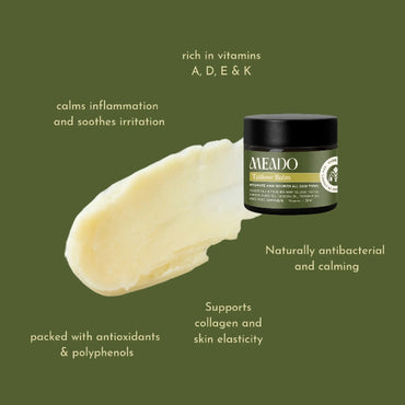 Meado tallow skin cream jar against a spread of cream and ingredients listed i the background. 