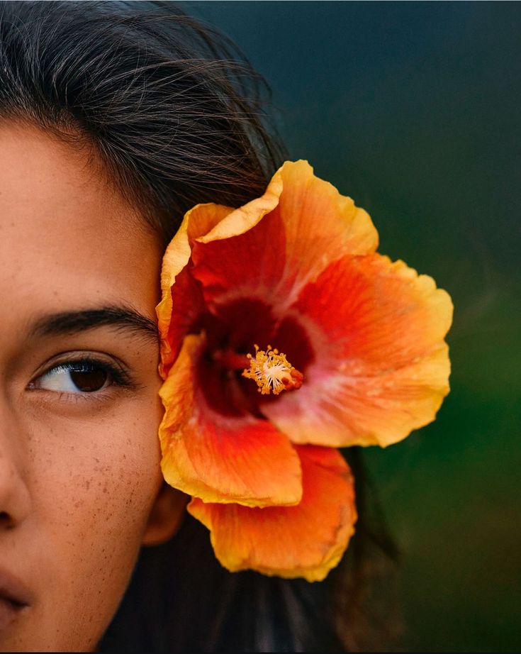 Beautiful women wearing a hibiscus flower in her ear