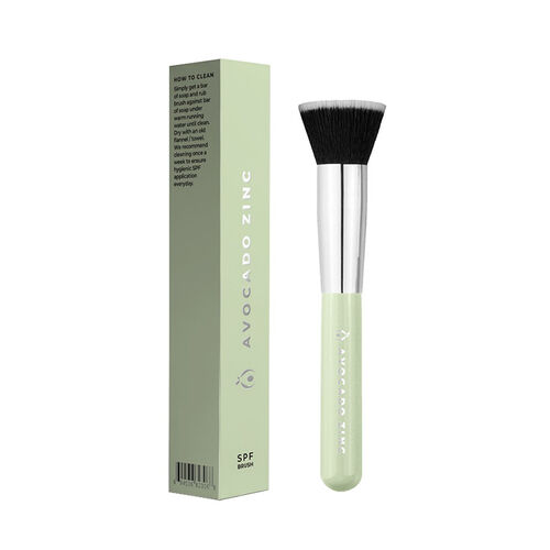 SPF Makeup brush with green handle and black bristle tip next to its packaging on a white background, brush by avocado zinc