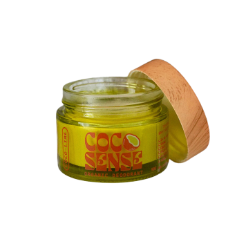 A jar of opened organic coconut deodorant by cocosense with the lid resting against the jar on a white background.