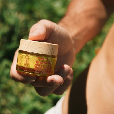 Mans hand holding a jar of organic coconut deodorant cream