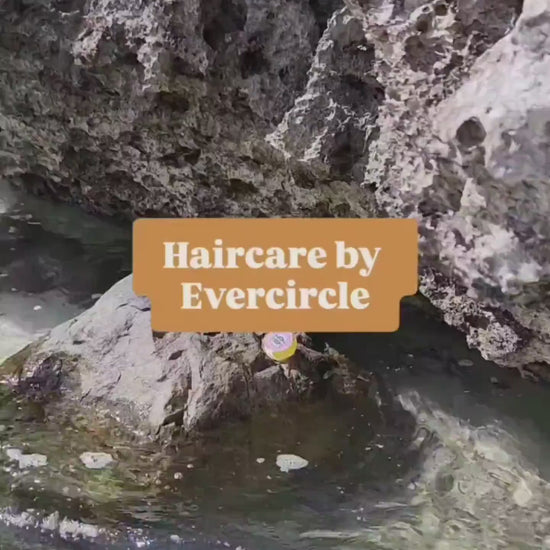 Women applying ocean hair protection serum at the beach. 