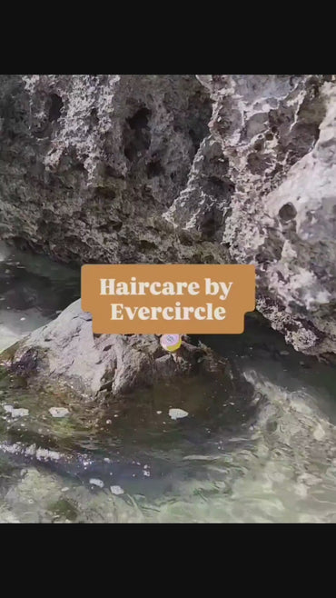 Women applying ocean hair protection serum at the beach. 