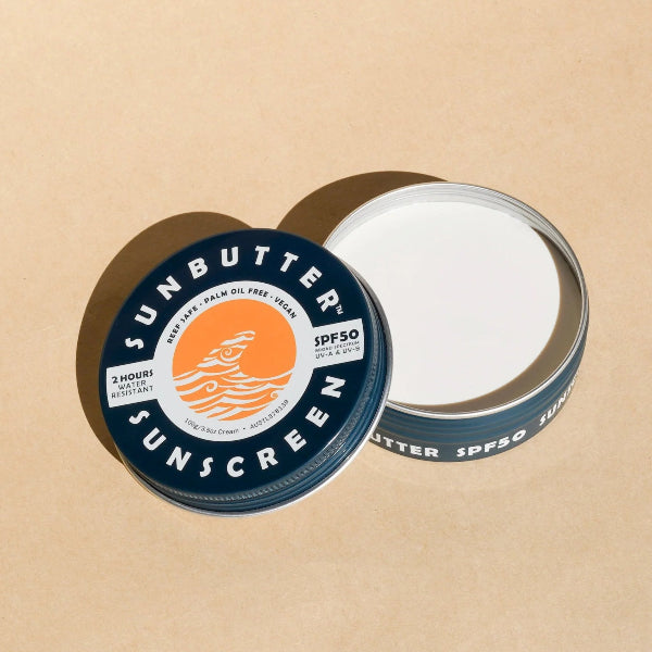 Tin of Sunbutter chemical free sunscreen against a peach background